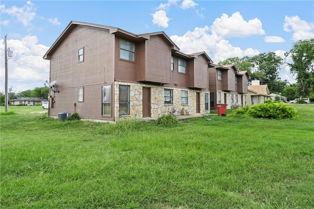 back of property with cooling unit and a yard