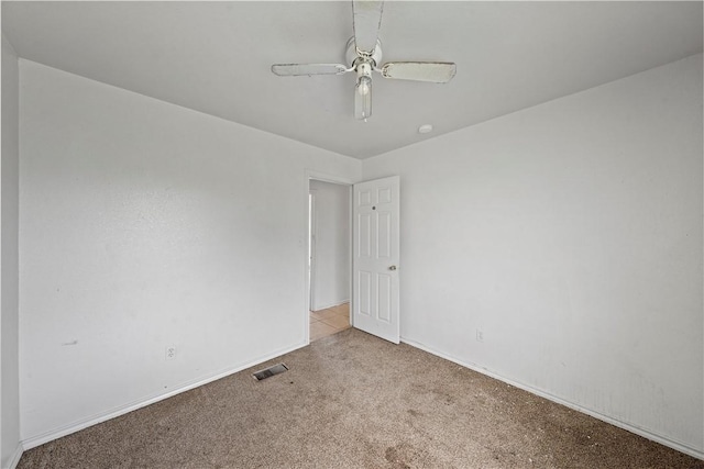 carpeted spare room with ceiling fan