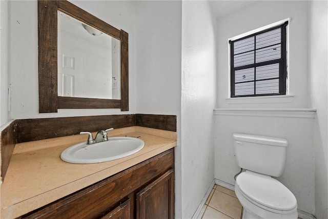 bathroom with tile patterned flooring, vanity, and toilet