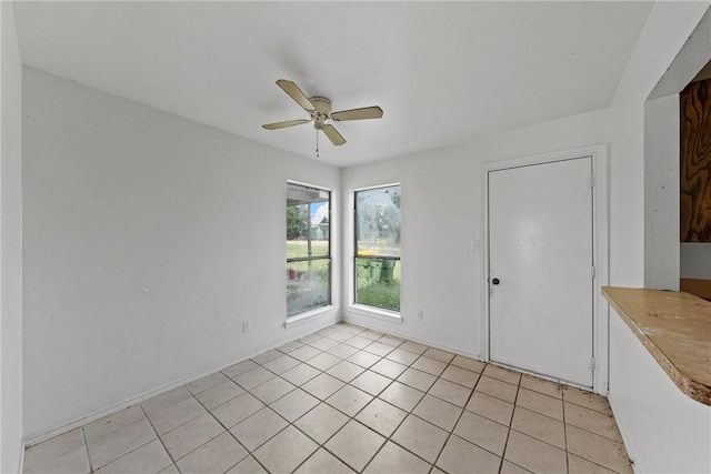 empty room featuring ceiling fan and light tile patterned floors