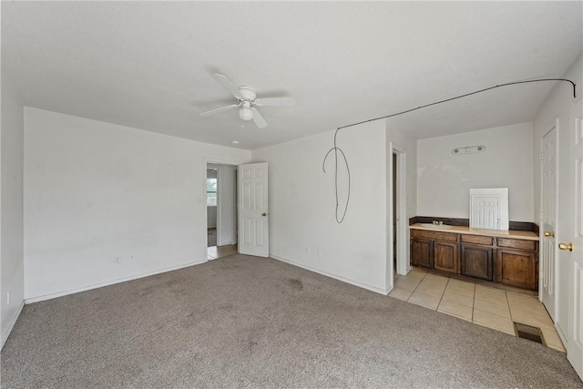 carpeted spare room featuring ceiling fan and sink