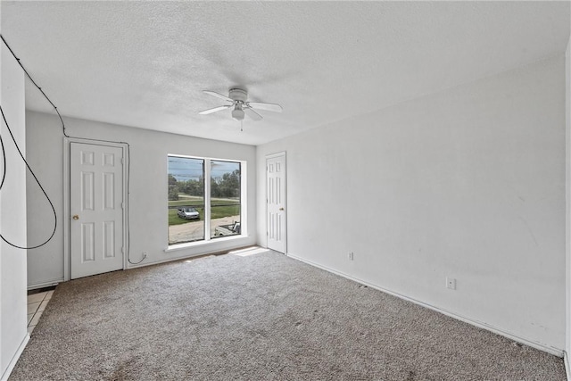 unfurnished bedroom featuring a textured ceiling, light colored carpet, and ceiling fan