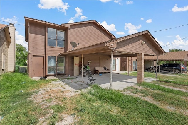 rear view of house with a yard and a carport