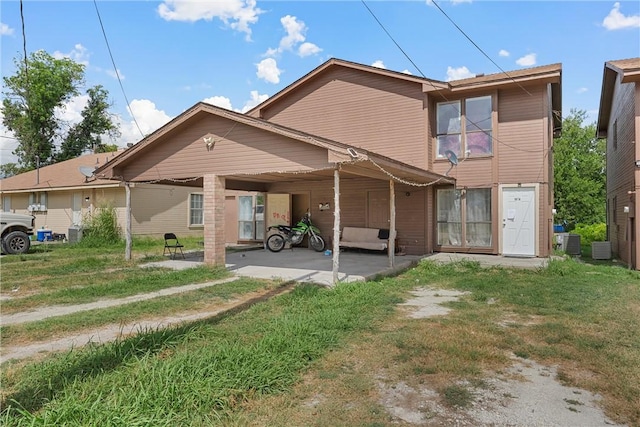 rear view of property featuring central air condition unit and a yard