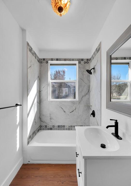 bathroom featuring vanity, tiled shower / bath combo, and hardwood / wood-style flooring