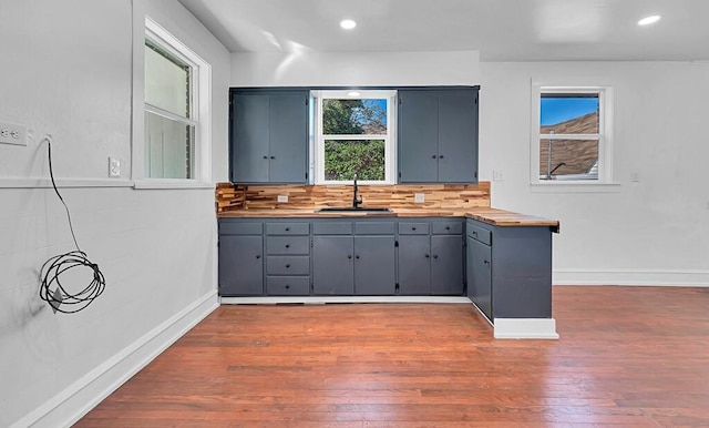 kitchen featuring backsplash, wood counters, sink, and dark wood-type flooring