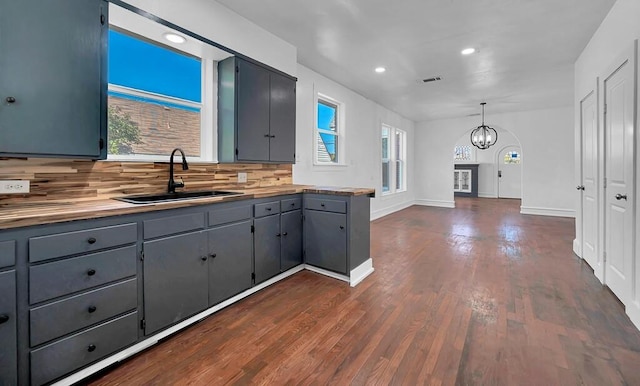 kitchen featuring hanging light fixtures, dark hardwood / wood-style floors, plenty of natural light, and sink