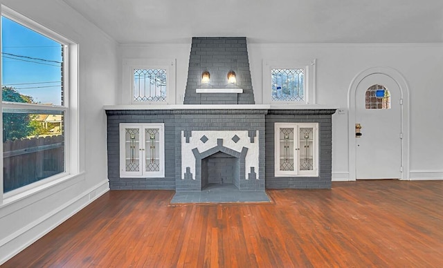 unfurnished living room featuring a fireplace, dark hardwood / wood-style floors, and plenty of natural light