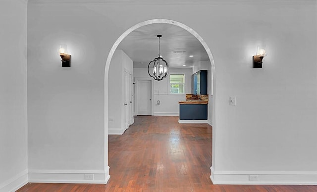 hall with hardwood / wood-style floors and a notable chandelier