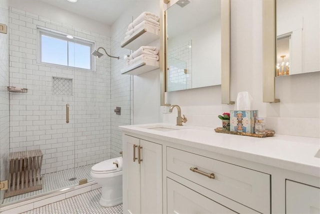 bathroom featuring toilet, tile patterned floors, an enclosed shower, and vanity