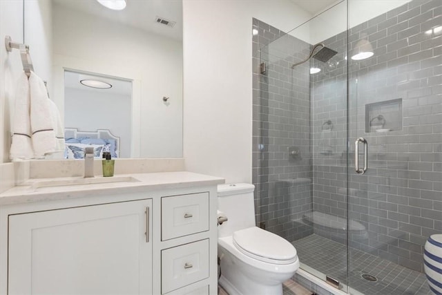 bathroom featuring toilet, vanity, and an enclosed shower