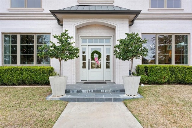 view of exterior entry featuring a yard