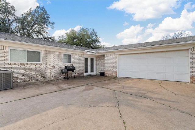 single story home featuring a garage, french doors, and central air condition unit