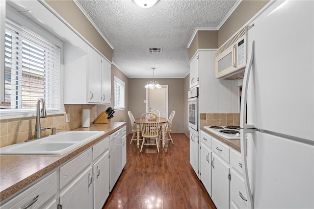 kitchen featuring sink, white cabinetry, decorative light fixtures, dark hardwood / wood-style floors, and white appliances