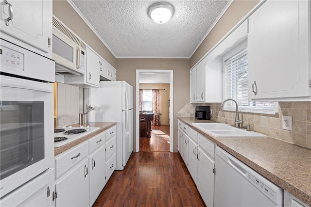 kitchen featuring white cabinetry, white appliances, sink, and a wealth of natural light