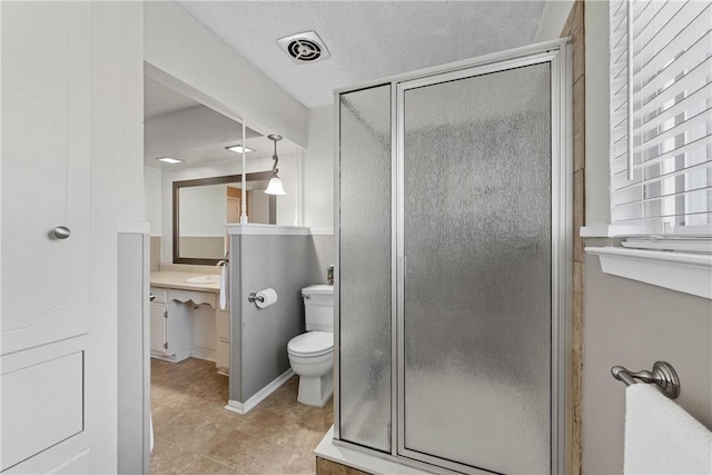 bathroom with a shower with shower door, tile patterned flooring, vanity, toilet, and a textured ceiling