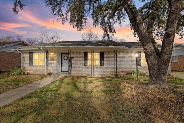 ranch-style house featuring a porch and a lawn