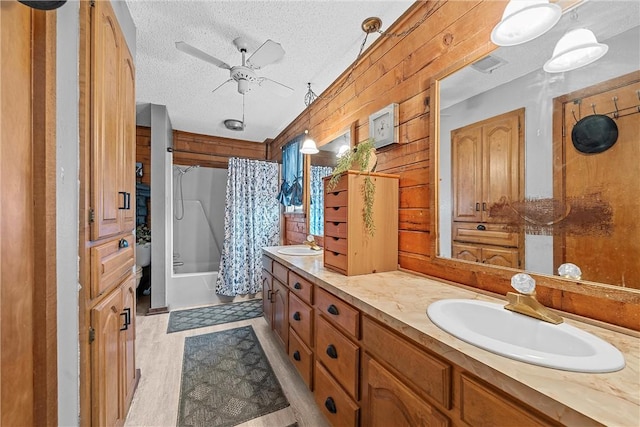 bathroom featuring shower / tub combo, a textured ceiling, ceiling fan, wooden walls, and wood-type flooring