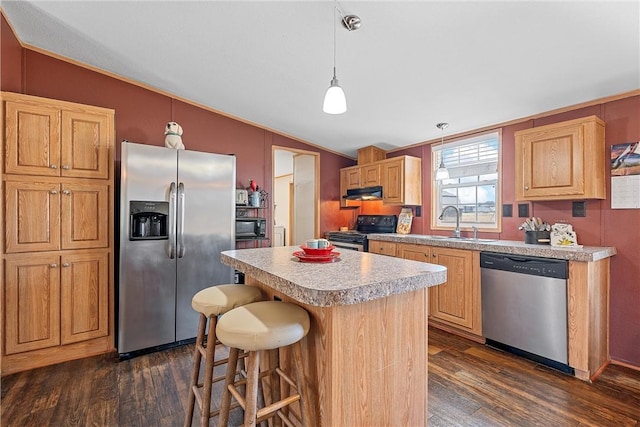 kitchen featuring a center island, lofted ceiling, black appliances, hanging light fixtures, and dark hardwood / wood-style floors