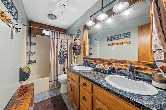 full bathroom with vanity, a textured ceiling, ceiling fan, shower / bathtub combination with curtain, and toilet