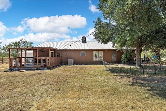 rear view of house with a lawn, central air condition unit, and a deck