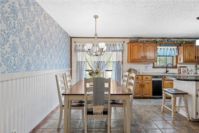 dining area featuring sink, a textured ceiling, and a notable chandelier