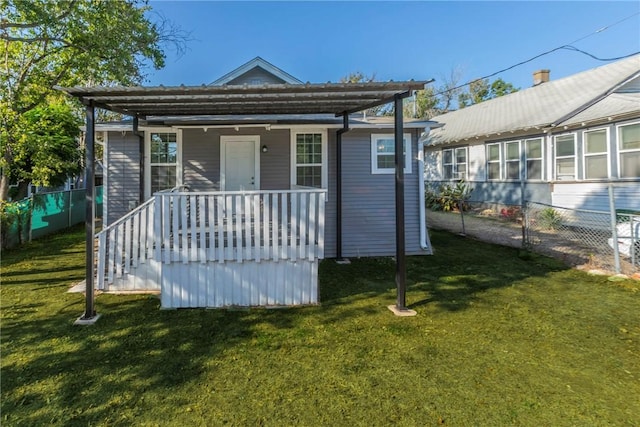 back of property with a carport and a yard