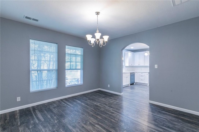 empty room with a chandelier and dark hardwood / wood-style floors