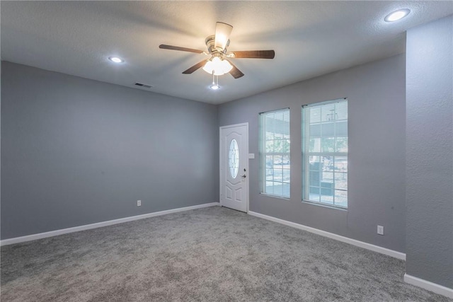 carpeted entryway featuring a textured ceiling and ceiling fan