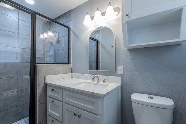 bathroom featuring vanity, toilet, and a shower with door