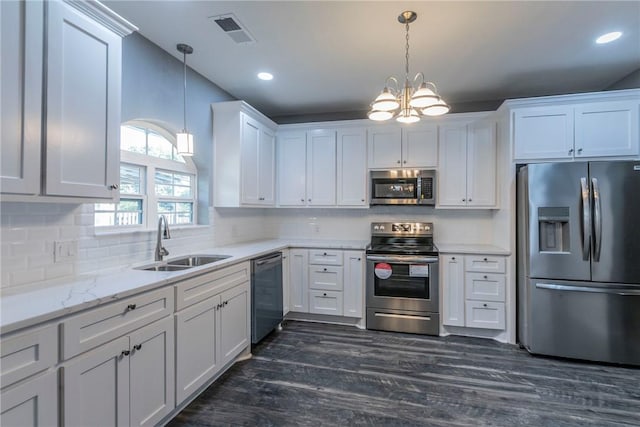 kitchen featuring white cabinets, sink, stainless steel appliances, and hanging light fixtures