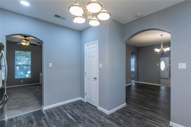 empty room featuring dark wood-type flooring and ceiling fan with notable chandelier