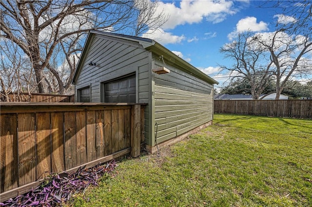 view of outdoor structure featuring a garage and a lawn