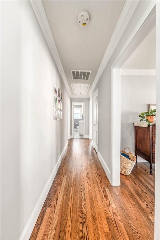 corridor with hardwood / wood-style flooring and ornamental molding