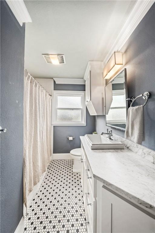 bathroom with vanity, crown molding, and toilet