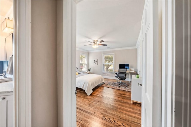 bedroom with ornamental molding, ceiling fan, and light hardwood / wood-style floors