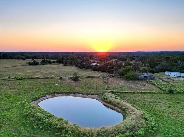 aerial view at dusk featuring a water view