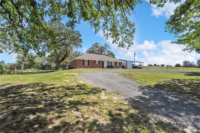 single story home featuring a rural view and a front lawn