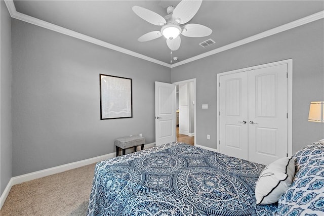 carpeted bedroom featuring ceiling fan, a closet, and ornamental molding