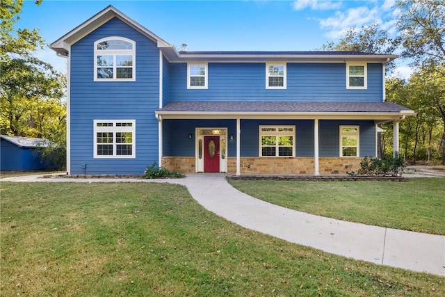 traditional home with stone siding, a porch, and a front yard