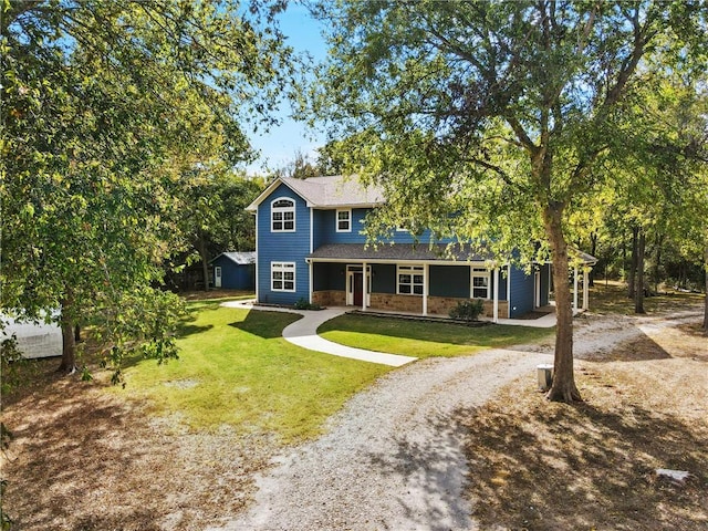 view of front of home with a porch, stone siding, driveway, and a front yard