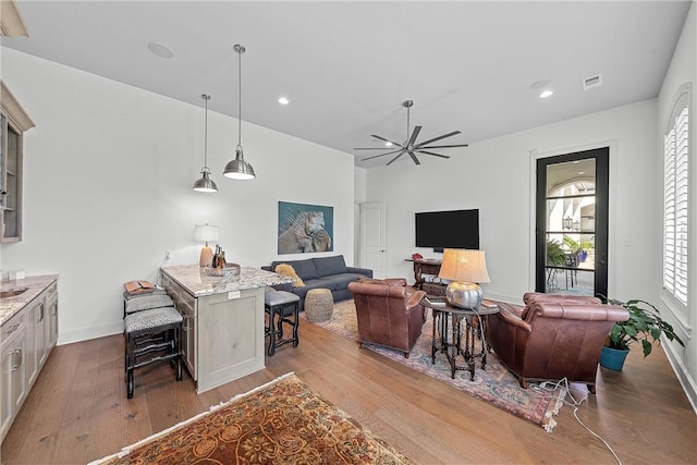 living room featuring ceiling fan and light hardwood / wood-style floors