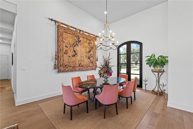 dining space featuring an inviting chandelier, wood-type flooring, and french doors