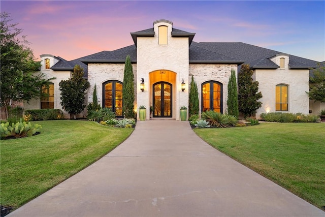 french country home with a lawn and french doors