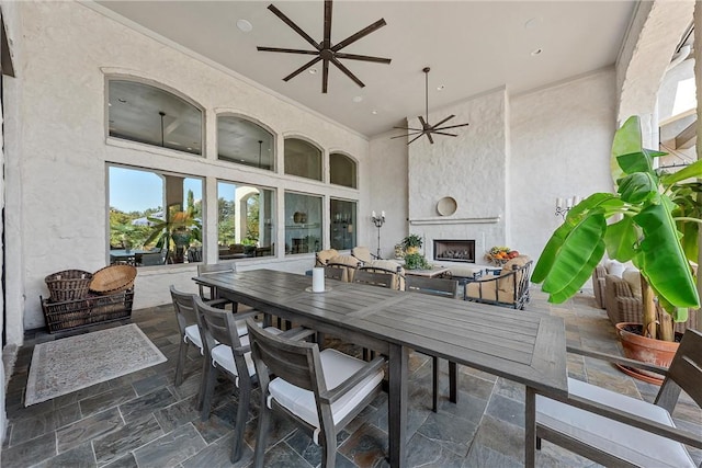 view of patio / terrace featuring ceiling fan and exterior fireplace