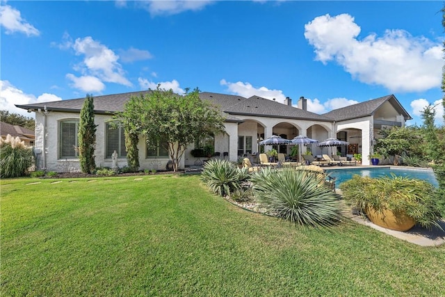 back of house featuring a patio and a lawn