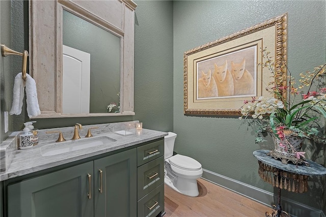 bathroom featuring vanity, hardwood / wood-style flooring, and toilet