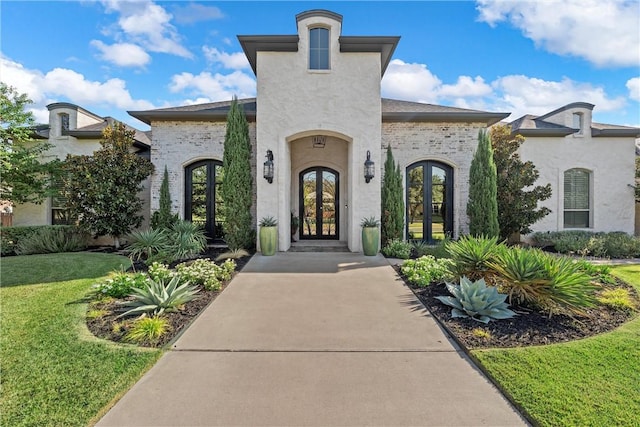 entrance to property with a yard and french doors