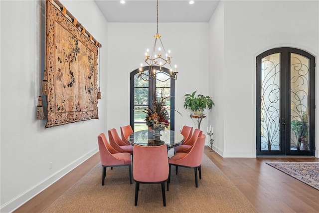 dining room featuring french doors, hardwood / wood-style floors, and an inviting chandelier