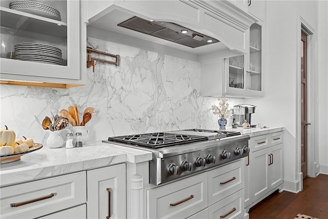 kitchen featuring white cabinetry, stainless steel gas cooktop, light stone counters, dark hardwood / wood-style flooring, and custom range hood